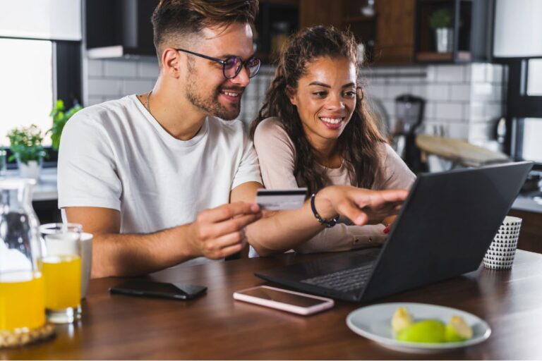 a smiling couple examines the flexible benefits offered by an employer on a laptop| Corporate Synergies